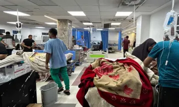 Israeli forces stand at the entrance of Gaza's primary hospital, where hundreds are confined.