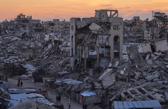 Palestinians sheltering amid damaged buildings and temporary camps in Gaza