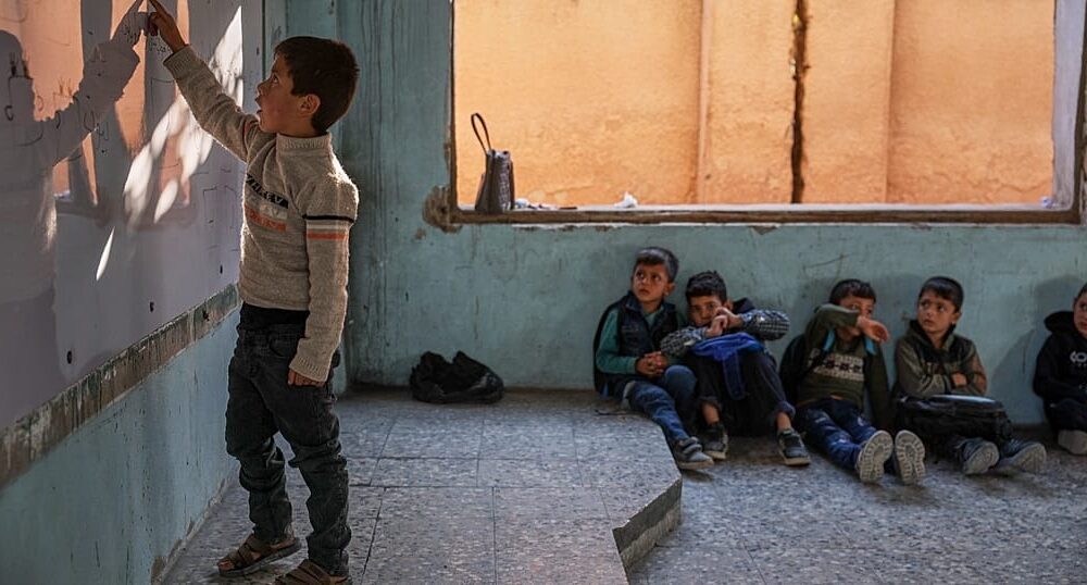 Syrian child walking home from school through a damaged area of Damascus