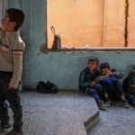 Syrian child walking home from school through a damaged area of Damascus